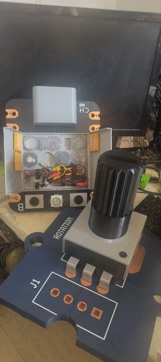 The giant rotary sensor next to the giant XIAO with its swappable interior open, for scale.