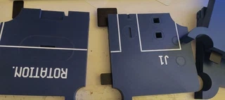 Two base plate quadrants apart on the table, with the small black key piece sitting between them.