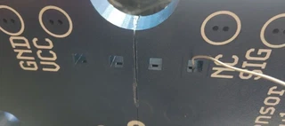 The back of the base plate showing the four small square holes for GND, VCC, NC, and SIG, with one wire already threaded through.