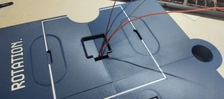 Four wires (red, brown, blue, and another) coming up through the collar&rsquo;s central hole, left long, before being routed down to the back.