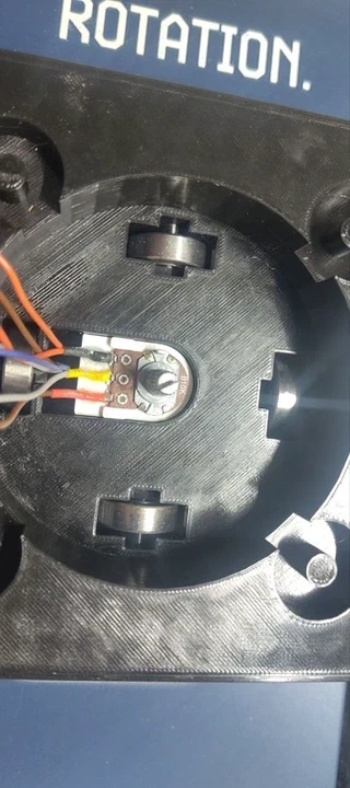 The real potentiometer soldered into place inside the body, wires routed out to the sides.
