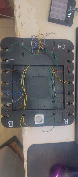 Wiring harness on the back of the board, and copper tape being assembled onto the pin pads.