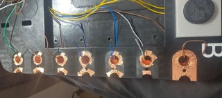 Close-up of the finished copper-tape pin connectors along the board edge, each with a wire soldered through the hole.