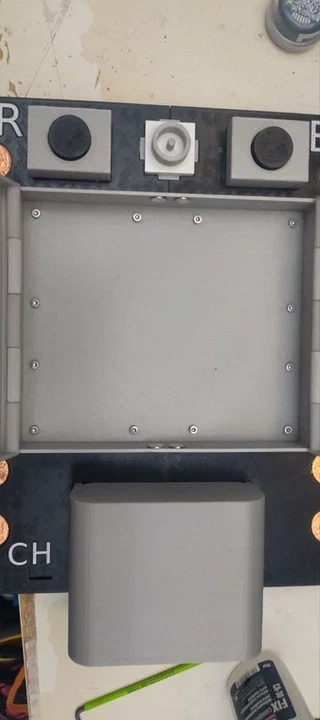 The chip housing box opened up on a hinge, showing the empty interior and two round neodymium magnets on the edge that hold the inner tray in place.